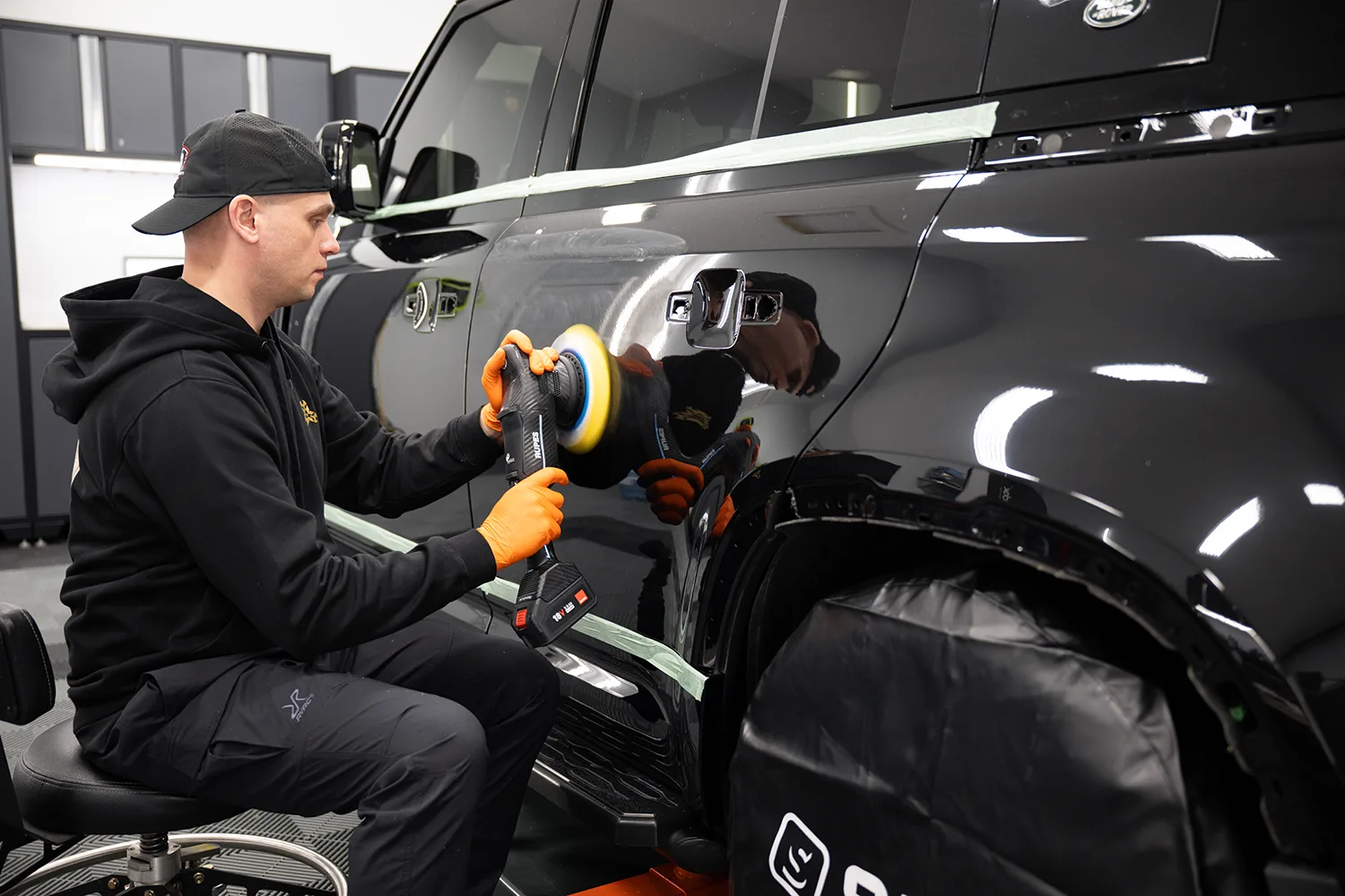 Close-up of machine polishing during paint correction on a dark Range Rover panel at Garage Knights Ottawa