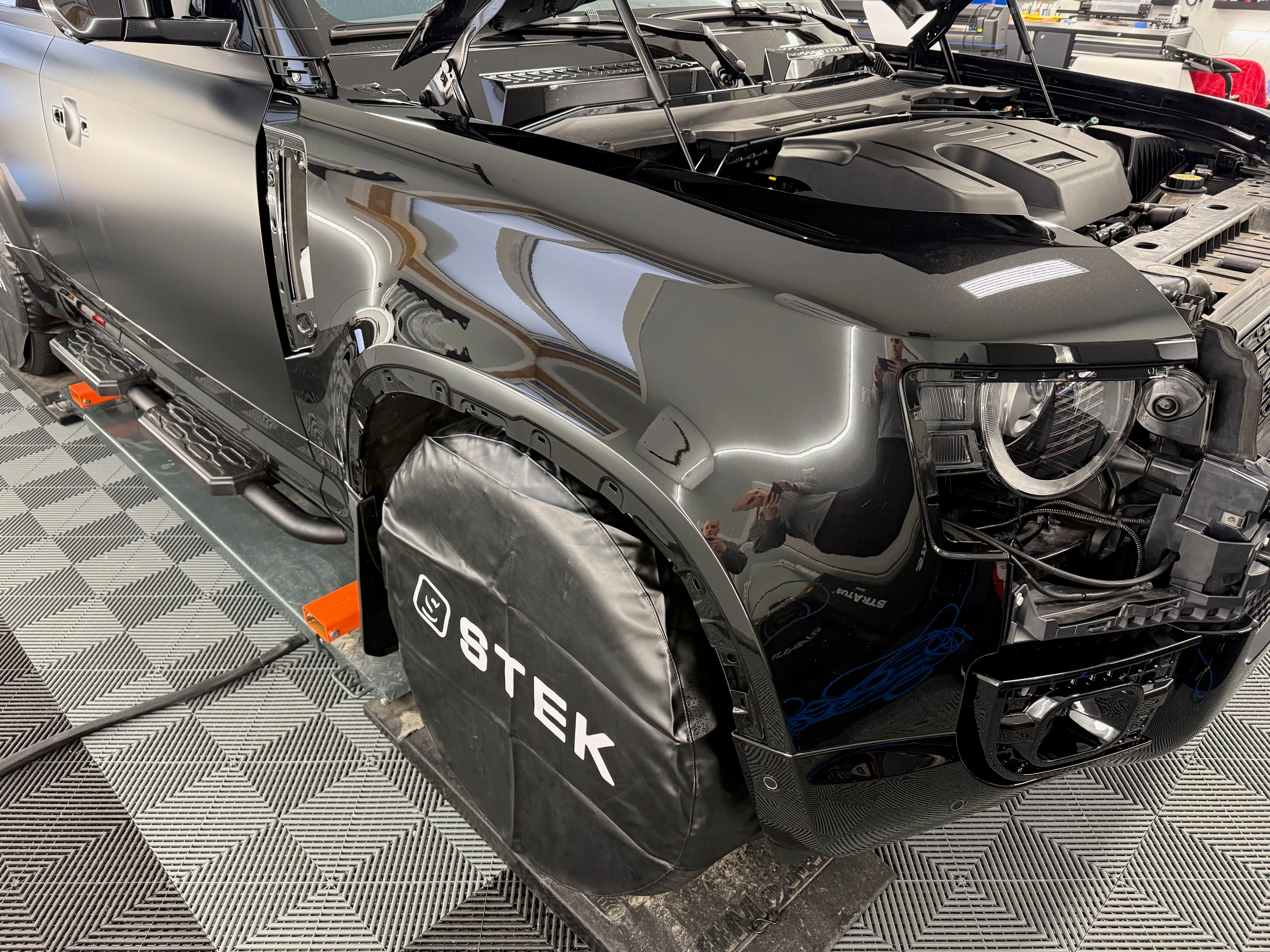 Land Rover Defender with headlights and front end disassembled for full paint protection film installation at Garage Knights Ottawa