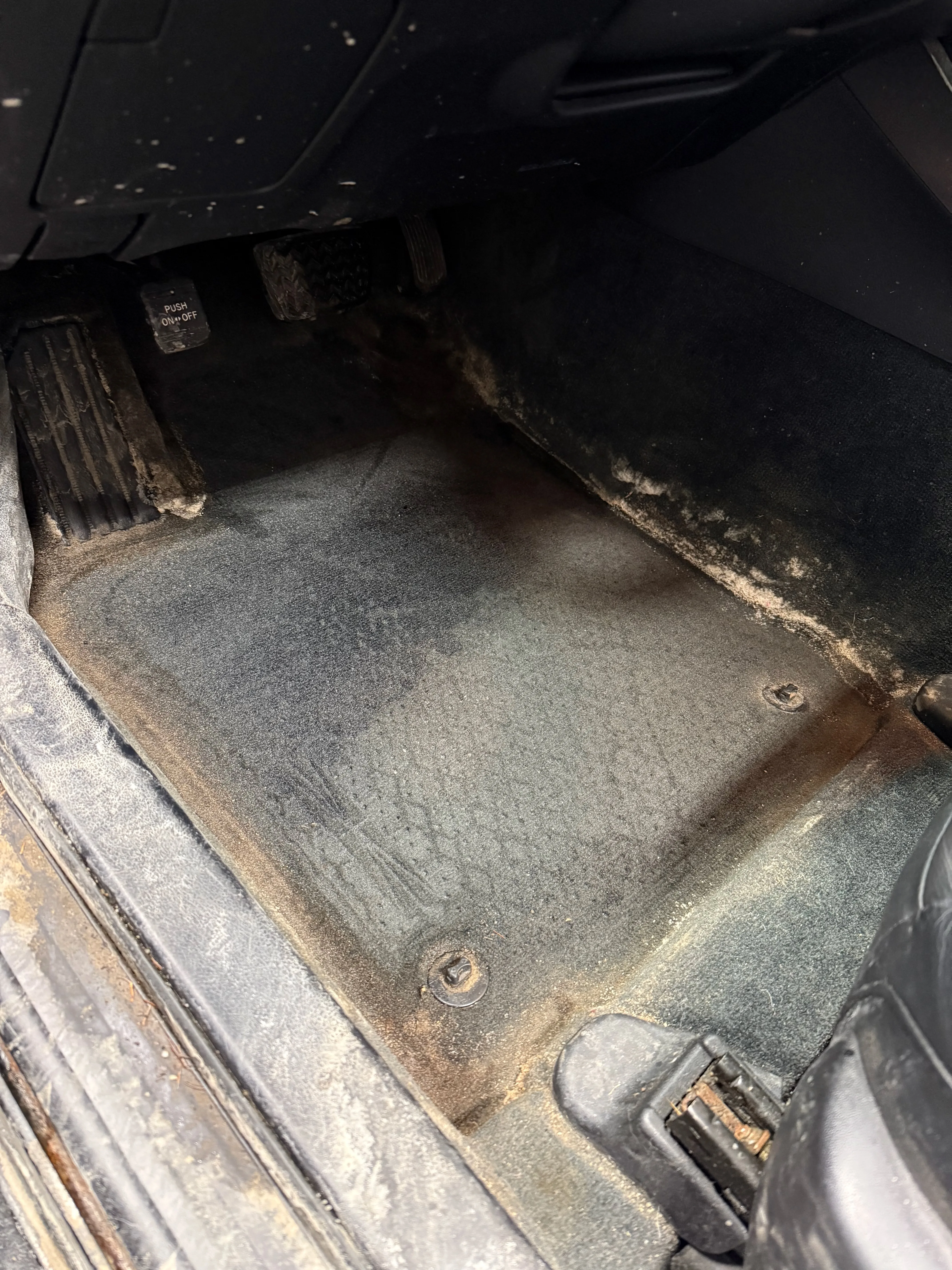 Close-up of heavy road salt stains on carpet before interior detailing