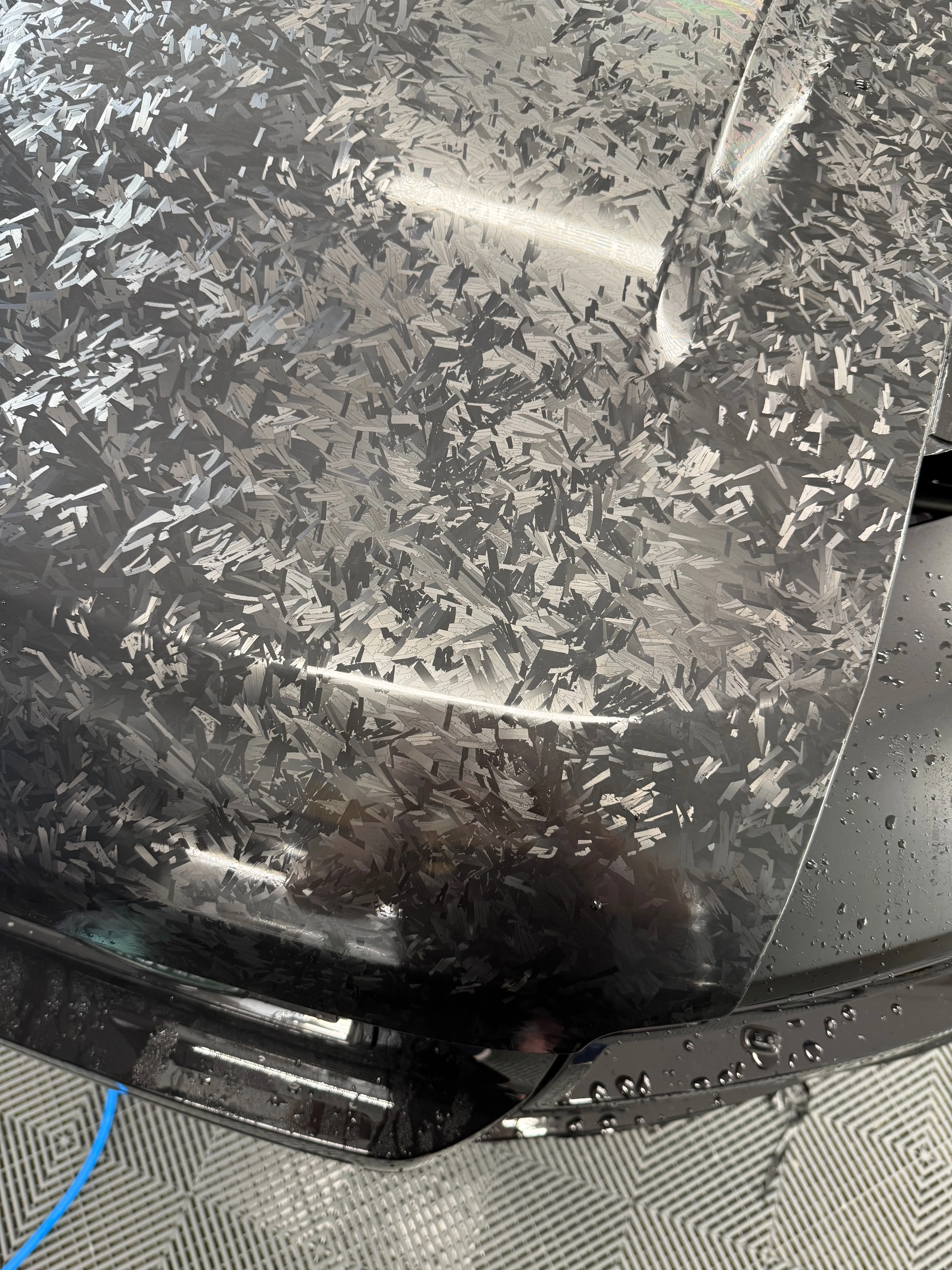 Forged carbon PPF on hood panel showing distinctive marbled texture