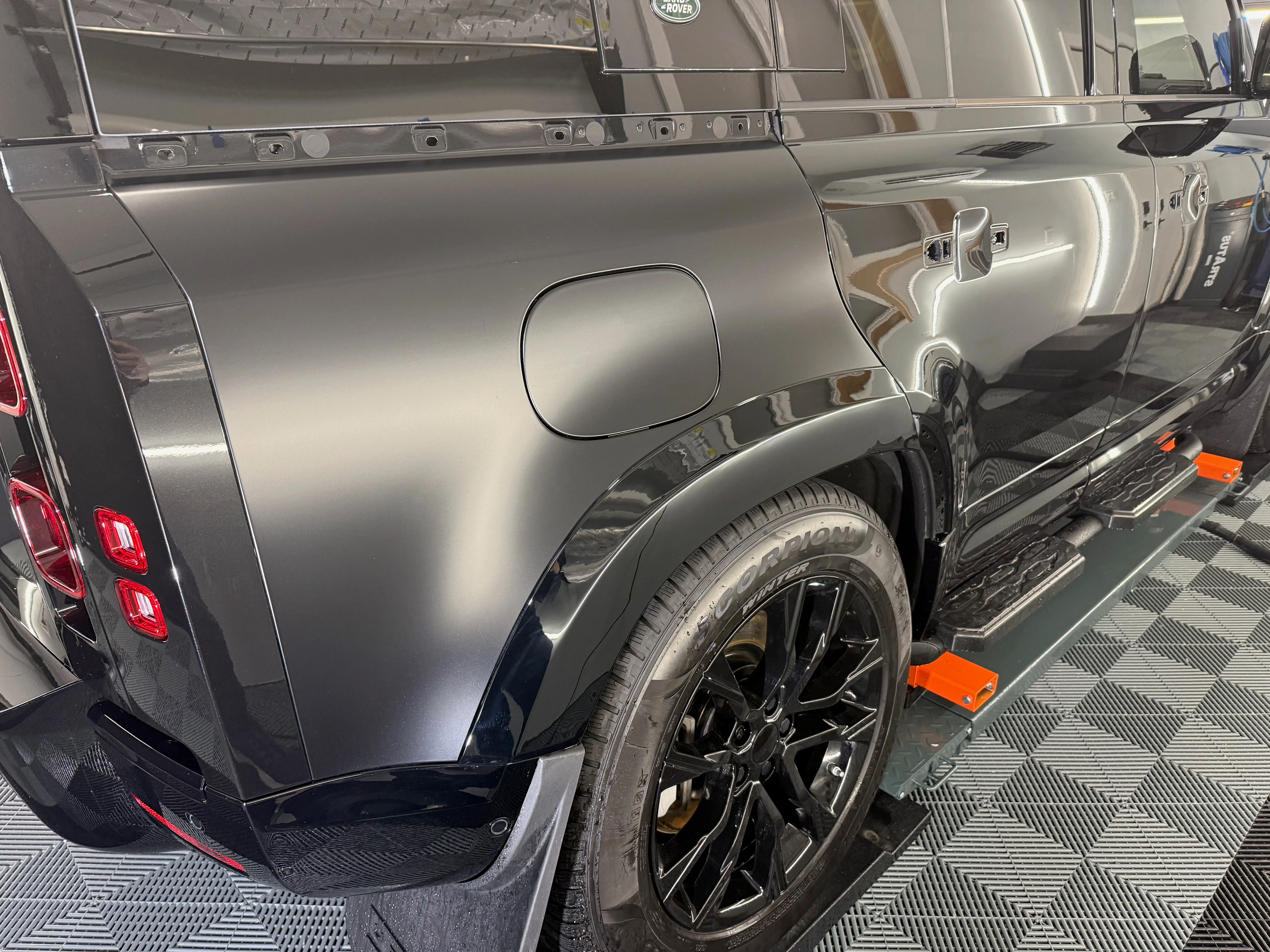 Land Rover Defender rear quarter with matte PPF on body panels and gloss black lower trim